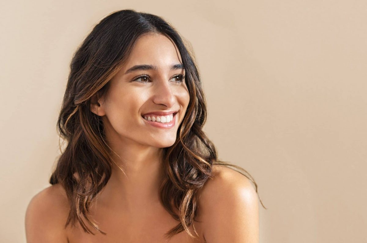 A woman with long brown hair smiling.