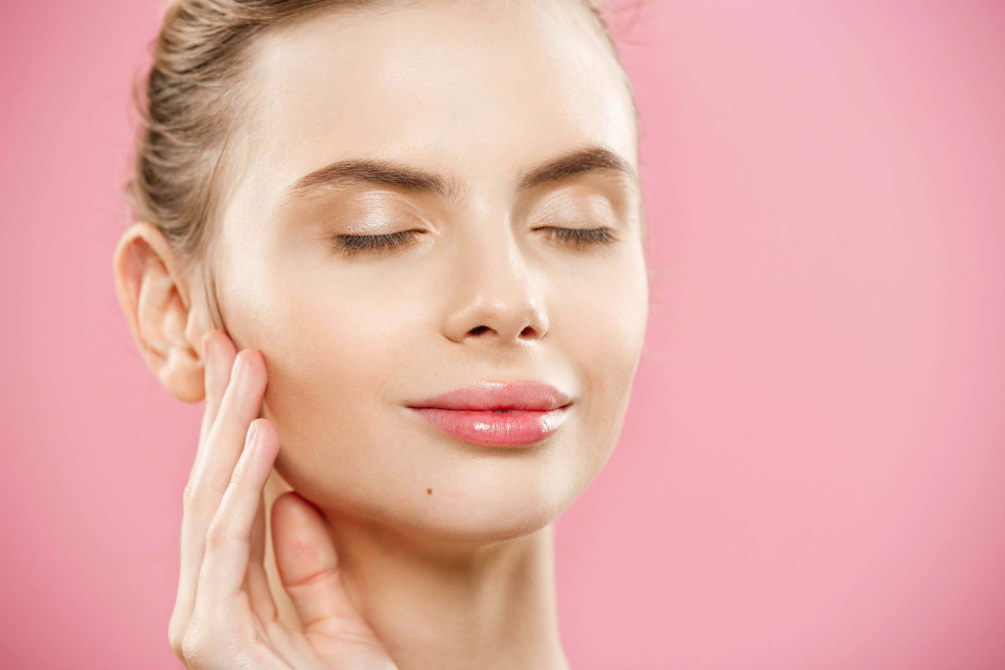 Beauty skin Concept - Beautiful Young Caucasian Woman with Clean Fresh Skin look away with pink