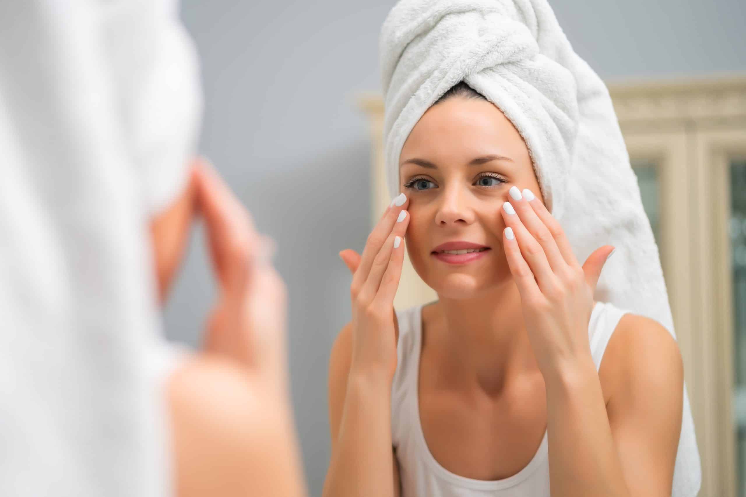 Woman looking in the mirror after completing her skincare routine