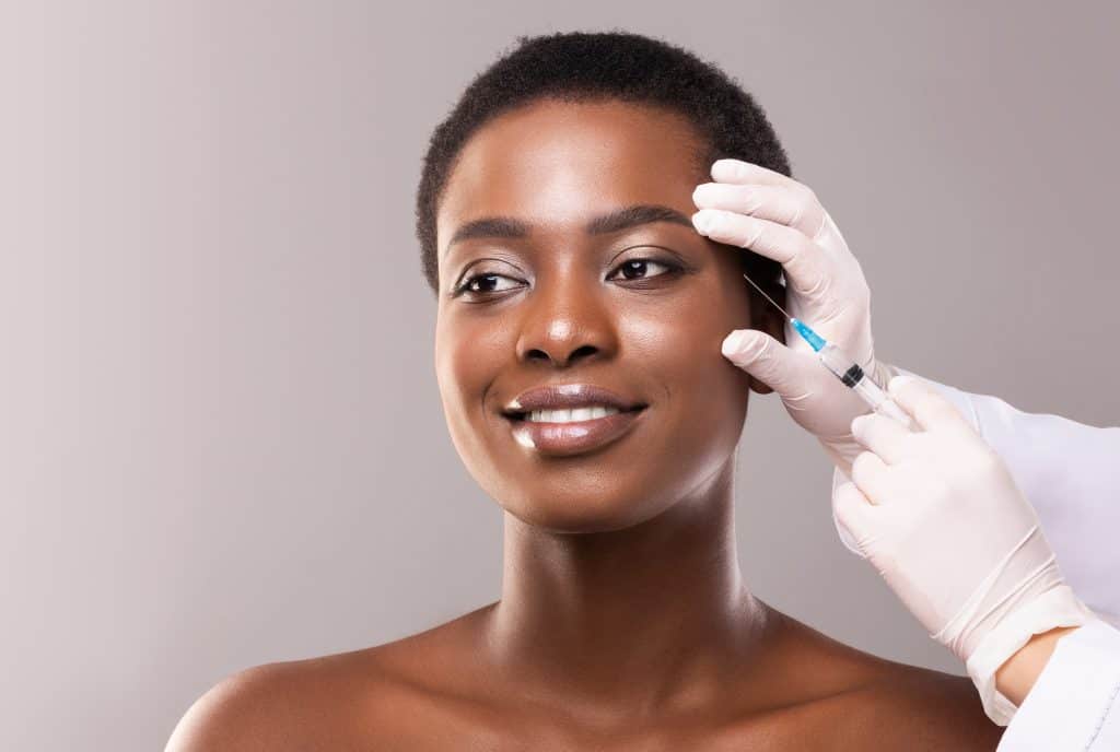 Woman receiving PDO Thread Lift treatment on her forehead.