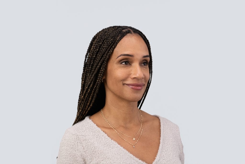 Woman with braided hair smiling, promoting dermal fillers in Scottsdale, AZ.